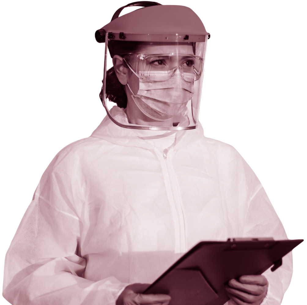 Woman holds a clipboard while wearing protective gear including white coverall, surgical mask, face shield, and goggles